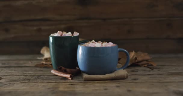 Två Koppar Varm Choklad Med Marshmallows Höstlöv Och Kanelstänger Träytan — Stockvideo