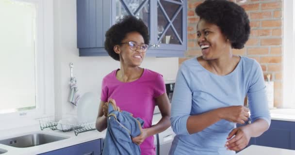 幸せなアフリカ系アメリカ人の母親と娘はキッチンで笑顔と抱擁 家庭での家庭生活と質の高い家庭生活 — ストック動画