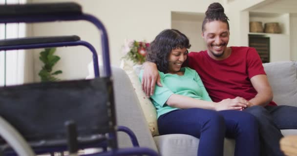 Счастливая Супружеская Пара Сидит Диване Обнимаясь Гостиной Инвалидной Коляской Переднем — стоковое видео