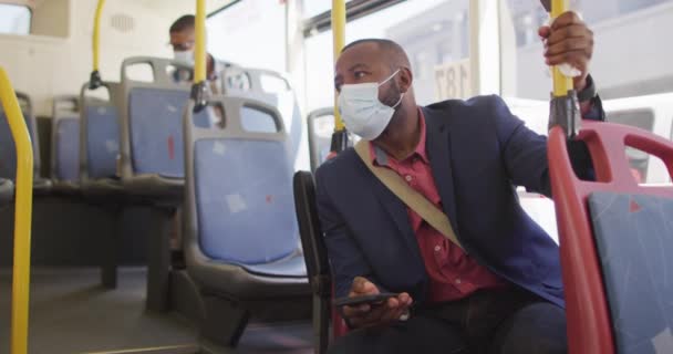 Afrikansk Amerikansk Man Stan Bär Ansiktsmask Med Smartphone Bussen Digital — Stockvideo