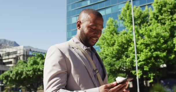 Şehirde Kahve Içen Akıllı Telefon Kullanan Mutlu Afro Amerikan Adam — Stok video