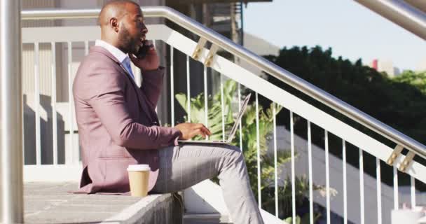 Şehirde Afro Amerikalı Bir Adam Elinde Kahve Akıllı Telefon Dizüstü — Stok video
