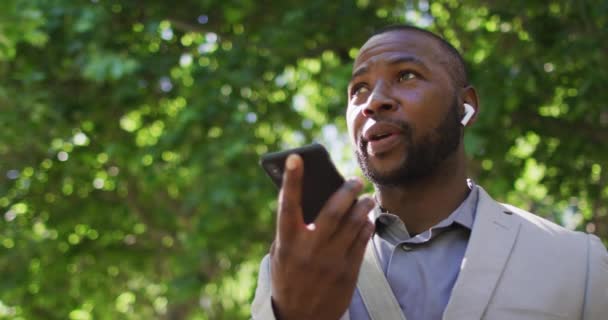 Şehirde Kulaklık Takan Akıllı Telefon Kullanan Mutlu Bir Afrikalı Amerikalının — Stok video