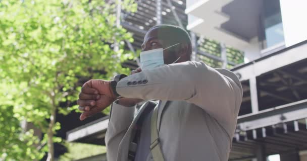 Hombre Afroamericano Ciudad Vistiendo Cara Usando Smartphone Mirando Smartwatch Nómada — Vídeo de stock