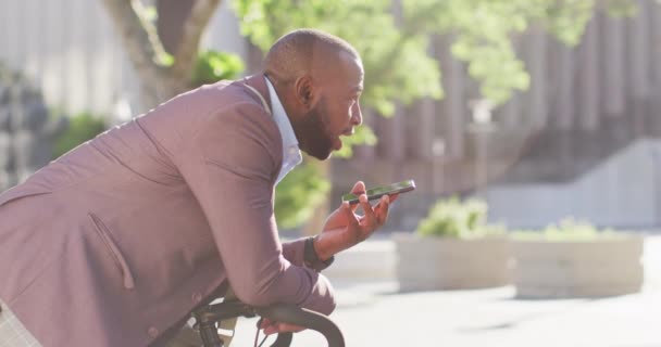 Bisikletli Afro Amerikan Bir Adam Akıllı Telefon Kullanarak Güneşin Altında — Stok video