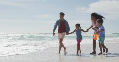 Mutlu İspanyol anne, baba, oğul ve kız sahilde oynuyorlar. Aile tatilleri, boş zaman ve birliktelik.