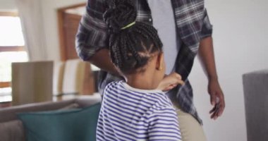 Mutlu Afro-Amerikan kızı babasıyla eğleniyor, oturma odasında dans ediyor. Evde ailece güzel vakit geçiririz..