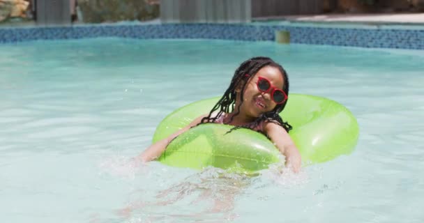 Glückliches Afrikanisches Amerikanisches Mädchen Mit Sonnenbrille Schwimmt Mit Aufblasbarem Ring — Stockvideo