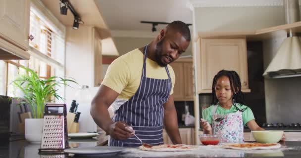 幸せなアフリカ系アメリカ人の父と娘がキッチンでピザを準備しています 質の高い家族の時間を — ストック動画