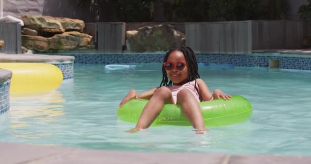 Happy African American Girl Wearing Sunglasses Floating Inflatable Ring Swimming — Stock Video