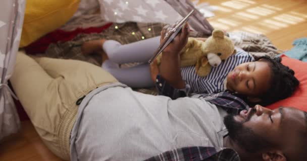 非裔美国人的父亲和女儿躺在帐篷里 使用带有复制空间的平板电脑 优质家庭团聚时间 — 图库视频影像