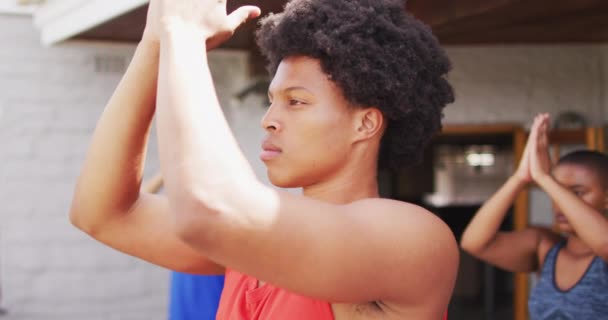 Afrikanischer Mann Praktiziert Yoga Mit Einer Gruppe Verschiedener Freunde Hinterhof — Stockvideo
