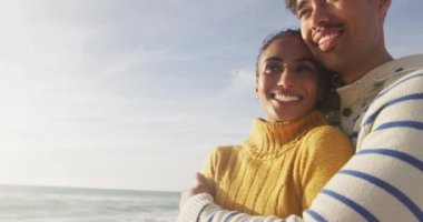 Mutlu İspanyol çiftin plajda ayakta ve kucaklaşan portresi. Tatiller, rahatlama, açık hava yaşam tarzı ve birliktelik..