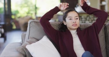 Biracial woman relaxing on sofa. domestic lifestyle and self care, enjoying leisure time at home.
