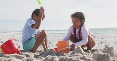 Mutlu İspanyol kardeşler kumsalda oynuyorlar ve kumdan kale yapıyorlar. Aile tatilleri, boş zaman ve birliktelik..