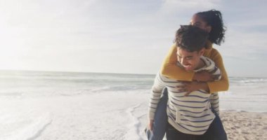 Mutlu İspanyol adam sırtında bir kadın taşıyor ve sahilde eğleniyor. Tatiller, rahatlama, açık hava yaşam tarzı ve birliktelik..