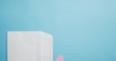 Sevgililer gününde mavi zemin üzerinde kırmızı ve pembe kağıt kalpler olan zarf. Sevgililer günü, aşk ve kutlama konsepti..