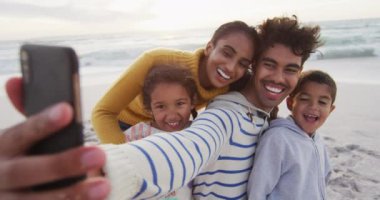 Mutlu İspanyol ailesi sahilde selfie çekiyor. Aile tatilleri, boş zaman, birliktelik ve dışarıda zaman geçirmek..