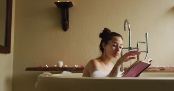 Relajada Mujer Birracial Acostada Baño Con Espuma Libro Lectura Belleza — Vídeos de Stock