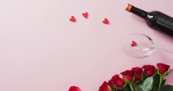 情人节那天 红玫瑰和葡萄酒杯 瓶装粉红色底色 情人节 爱与庆祝的概念 — 图库视频影像