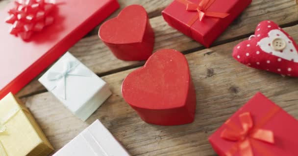 バレンタインデーの木製の背景に木製の心と贈り物 バレンタインデー愛とお祝いのコンセプト — ストック動画