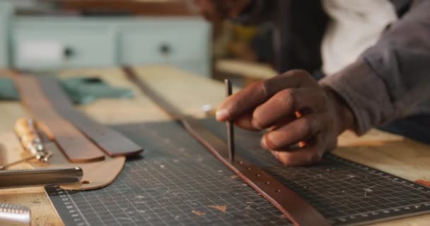 Руки Африканского Американского Ремесленника Используют Инструменты Сделать Дыру Кожаной Мастерской — стоковое видео