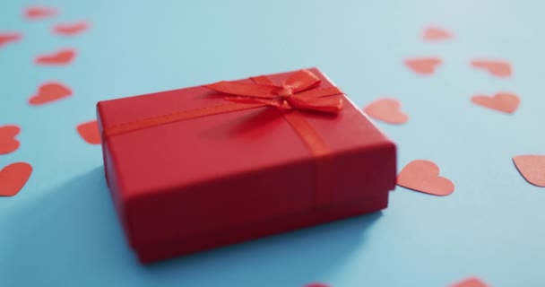 青い背景にバレンタインデーに複数の赤い紙の心と赤いプレゼント バレンタインデー愛とお祝いのコンセプト — ストック動画