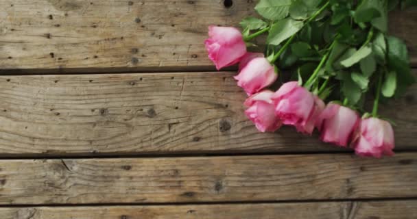 バレンタインデーの木製の背景にピンクのバラの花束 バレンタインデー愛とお祝いのコンセプト — ストック動画