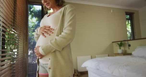 Sección Media Mujer Embarazada Caucásica Pie Ventana Tocando Vientre Embarazo — Vídeos de Stock