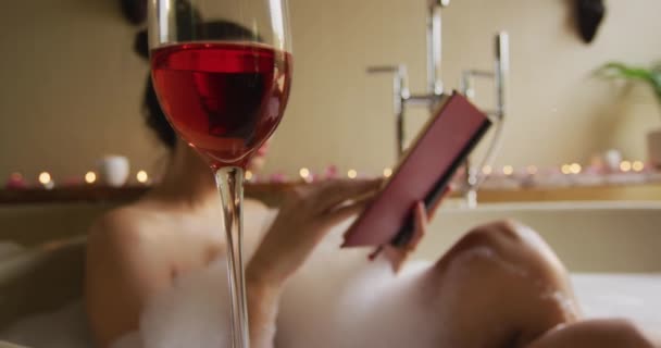 Verre Vin Sur Femme Biraciale Heureuse Dans Bain Avec Livre — Video