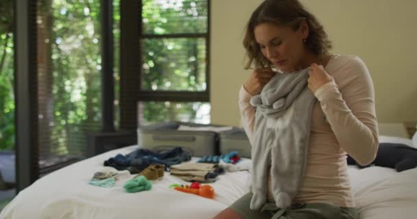 Happy Caucasian Pregnant Woman Looking Baby Clothes While Packing Suitcase — Stock Video