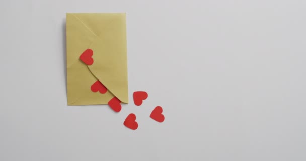 バレンタインデーのピンクの背景に紙の心と封筒 バレンタインデー愛とお祝いのコンセプト — ストック動画