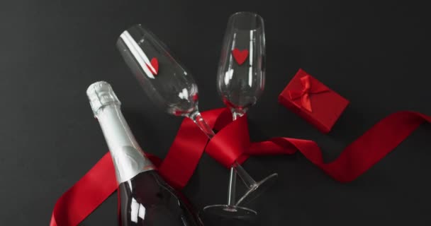 バレンタインデーにプレゼントとレッドリボンのシャンパングラスとボトル バレンタインデー愛とお祝いのコンセプト — ストック動画