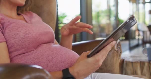 使用石碑坐在扶手椅上的高加索孕妇的中间部分 技术和在家里度过的时间 — 图库视频影像