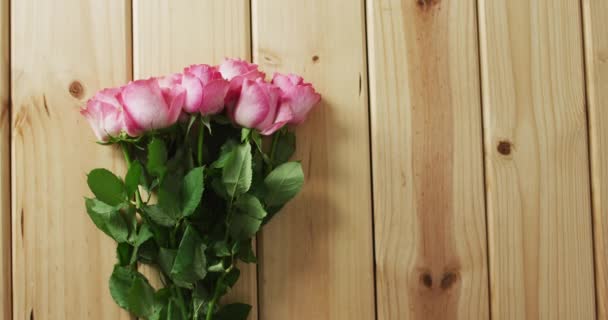 情人节那天 一束粉红色的玫瑰在木制背景上飘扬 情人节 爱与庆祝的概念 — 图库视频影像