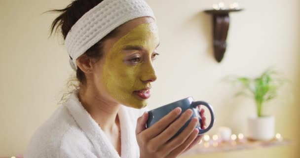 Avslappnad Biracial Kvinna Med Ansiktsmask Dricka Kaffe Skönhet Välbefinnande Och — Stockvideo