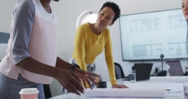 Group of diverse businesswomen in discussion standing over desk in meeting. independent creative business, working at a modern office.