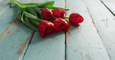 Sevgililer gününde ahşap arka planda bir buket kırmızı lale. Sevgililer günü, aşk ve kutlama konsepti..