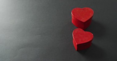 Sevgililer gününde gri arka planda kırmızı kalpler kutuları şekillendirir. Sevgililer günü, aşk ve kutlama konsepti..