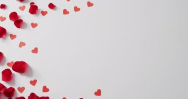 Sevgililer gününde beyaz arka planda kağıt kalpler ve taç yaprakları. Sevgililer günü, aşk ve kutlama konsepti..