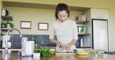 Melez kadın mutfakta meyve püresi için sebze hazırlıyor. Sağlıklı yaşam tarzı ve evde boş vakitlerin tadını çıkarmak..