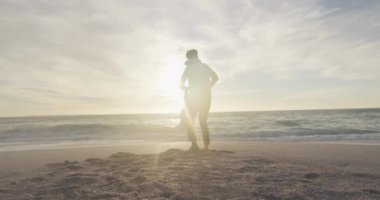 İspanyol baba oğluyla gün batımında sahilde oynuyor. Aile tatilleri, boş zaman, birliktelik ve dışarıda zaman geçirmek..