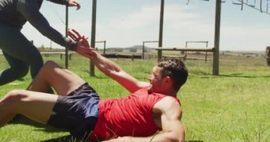 Engel parkurundaki beyaz adam kadın meslektaşı tarafından ayağa kaldırıldı. Sağlıklı aktif yaşam tarzı, acemi birliğinde çapraz eğitim..