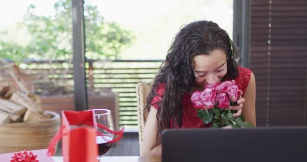 快乐的女人在笔记本电脑上做情人节视频拜访 闻玫瑰的味道 情人节庆祝活动 浪漫与交流技术 — 图库视频影像