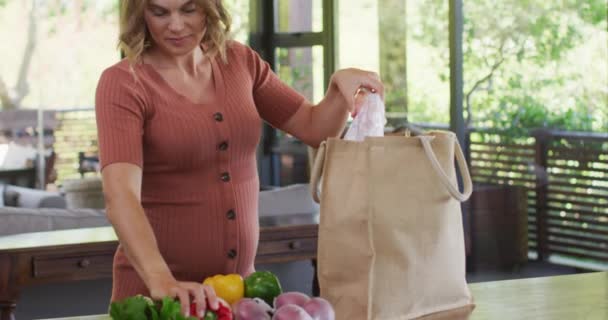 Biała Kobieta Ciąży Rozpakowuje Torbę Zakupami Kuchni Spodziewa Się Dziecka — Wideo stockowe