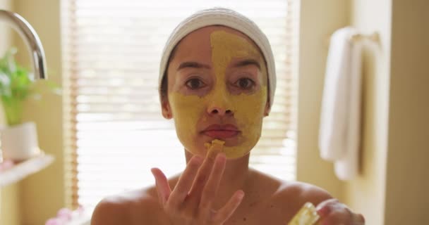 Portrait Femme Biraciale Regardant Dans Miroir Appliquant Masque Facial Beauté — Video