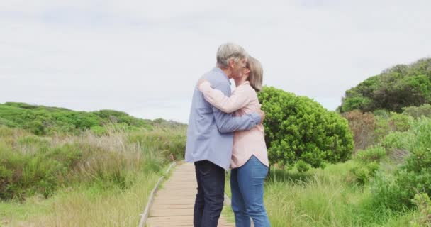 Χαμογελώντας Ηλικιωμένο Καυκάσιο Ζευγάρι Αγκαλιάζει Και Περπατά Στο Μονοπάτι Έξω — Αρχείο Βίντεο