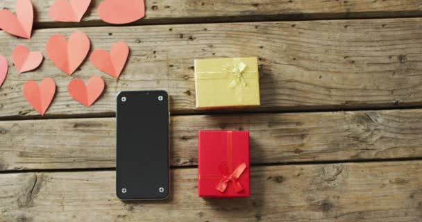 情人节礼物的纸心和智能手机 木制背景 情人节 爱与庆祝的概念 — 图库视频影像