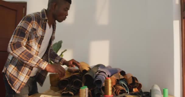 Afrykański Amerykanin Szukający Materiału Warsztacie Skórzanym Niezależny Rzemieślnik Małych Przedsiębiorstw — Wideo stockowe