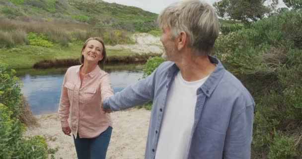 Smiling Senior Caucasian Couple Holding Hands Walking River Active Retirement — Stockvideo